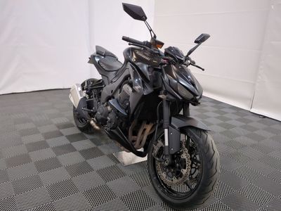une photo d'une moto noire garée sur un sol à damier