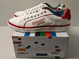 Quelqu'un porte une paire de baskets blanches ornées d'un motif coloré.