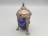 un bocal ancien en argent et en verre bleu, posé sur un socle