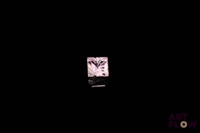 a close up of a square pink diamond on a black surface