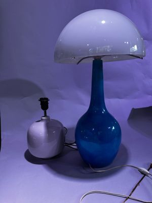 une lampe de table en verre bleu surmontée d'un dôme blanc