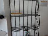 a metal shelf with magazines on it in the corner of a room
