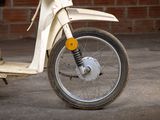 a motor scooter that is parked in front of a brick wall