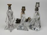 trois lampes en verre transparent posées les unes à côté des autres sur une surface blanche