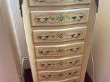 a white vase on top of a chest of drawers
