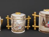 three porcelain teapots and a coffee pot on a black surface