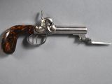 a close up of a gun on a table with a knife