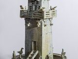 une petite statue représentant une tour surmontée d'oiseaux