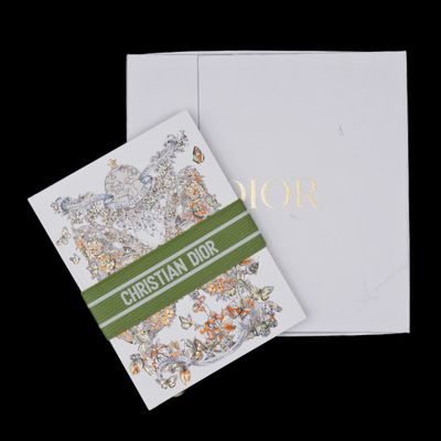 a close up of a white card with a green ribbon on it