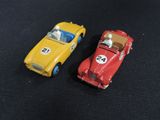 two toy cars sitting next to each other on a black surface