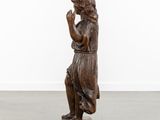 a wooden statue of a man with a hat on his head