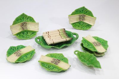 cinq morceaux de nourriture sur une assiette verte ornée de feuilles
