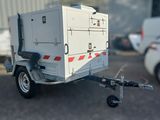 une petite caravane blanche à laquelle est attelée une remorque