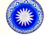 a blue glass bowl with a white flower in it