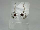 a pair of silver earrings with garnets on them