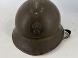 an old military helmet with a leaf on the top of it