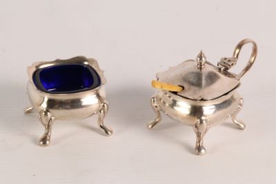 pair of silver plated sugar dishes with blue glass in them