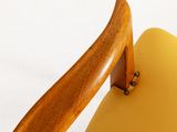 a close up of a yellow chair with a wooden handle