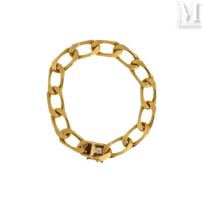gros plan d'un bracelet en chaîne en or sur fond blanc
