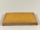 an old book sitting on top of a table next to a white wall