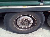 a close up of a flat tire on a green truck