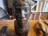 a bust of a man sitting on top of a wooden table