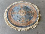 un tapis rond posé à même le sol, orné de franges