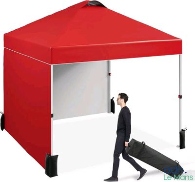 a man walking under a red tent with a suitcase