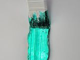 a paint brush with green paint on it on a white surface