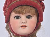 a close up of a doll wearing a red hat