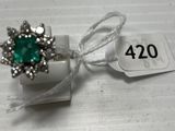 a ring with a green stone in it on a white box