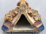 a gold and blue birdhouse on a white surface