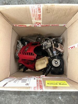 une boîte posée par terre, contenant une moto