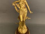 an image of a statue of a woman holding a bird on top of a wooden base