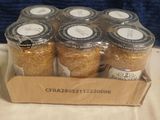 six jars of cereal sit in a cardboard box on a table