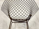 a black wire chair on a white sheet on a bed