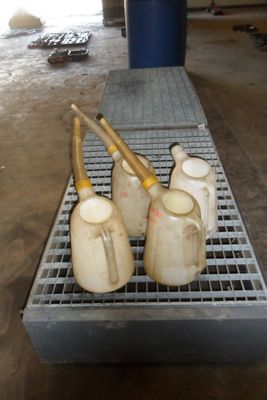 trois vases posés sur une grille métallique dans une pièce