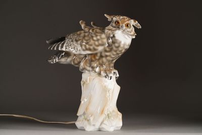 a statue of an owl sitting on top of a tree stump