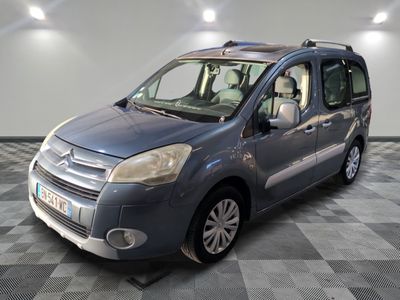 the small blue van is parked on a checkered tile floor