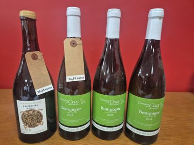 quatre bouteilles de vin sont alignées sur une table en bois