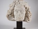une image représentant une sculpture de tête de femme aux cheveux bouclés