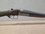 a close up of a rifle on a table with a wall in the background