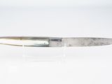 un couteau posé sur une surface blanche