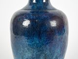 a blue vase that is sitting on a white surface