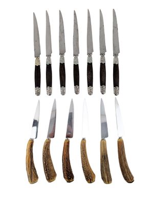 six knives are lined up in a row on a white surface