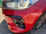 the front end of a red sports car parked in a parking lot