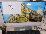 un écran d'ordinateur posé sur un bureau avec un clavier et une souris