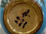 a blue and gold vase with a picture of a bird on it