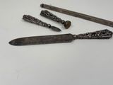 four different types of knives and a knife holder on a white surface