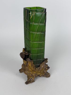 a green vase sitting on top of a tree stump